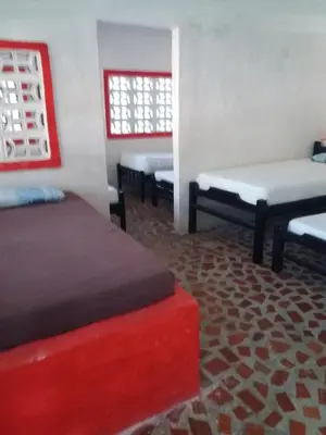a room with three beds and a red at MAR SERENO Recinto Natural Casa Museo MERY LORA de CIFUENTES Condominio de Cabañas frente al MAR in Coveñas