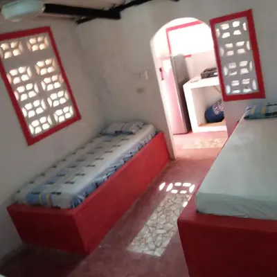 a small room with a bed and two windows at MAR SERENO Recinto Natural Casa Museo MERY LORA de CIFUENTES Condominio de Cabañas frente al MAR in Coveñas