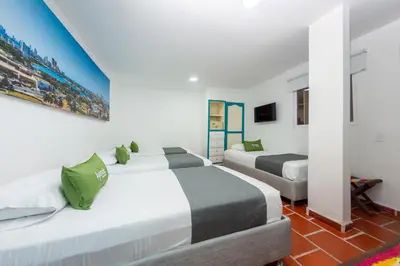 two beds in a room with white walls and green pillows at Hotel Ayenda Cartagena Blue 1804 in Cartagena de Indias