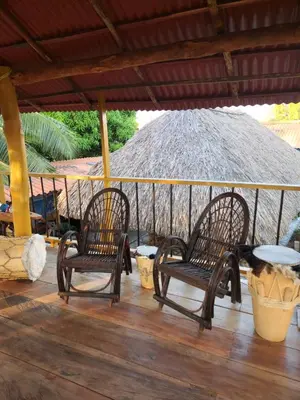 two chairs and a table on a porch with an umbrella at Alojamiento Bityn in Paso Nuevo