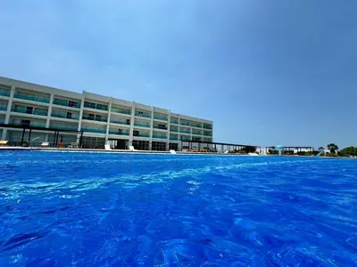 a large building with blue water in front of it at Marina Puerto Velero in Tubará