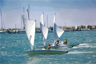 a group of people on boats with sails in the water at Marina Puerto Velero in Tubará