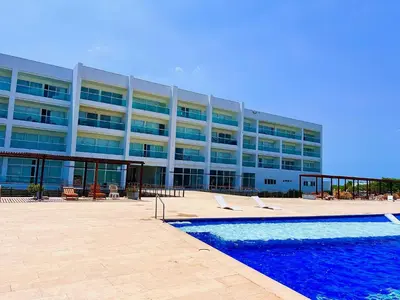 a large building with a swimming pool in front of it at Marina Puerto Velero in Tubará