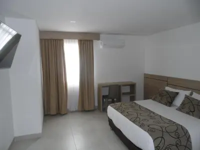 a hotel room with a bed and a window at Hotel Arawak Plaza in Sincelejo