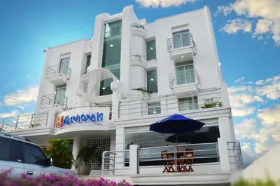a white building with an umbrella in front of it at Hotel Arawak Plaza in Sincelejo