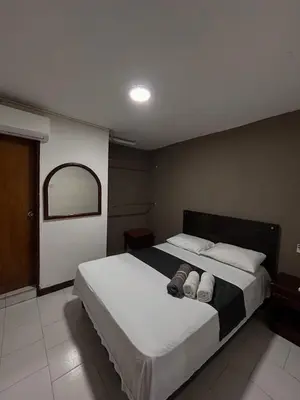 a bedroom with a large bed with two towels on it at Hotel Exito Barranquilla in Barranquilla