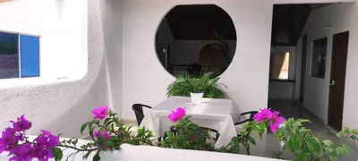 a table with purple flowers in front of a mirror at host Casa Don Arturo in Santa Marta
