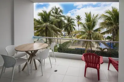 a balcony with a table and chairs and palm trees at Magico Apartamento Frente al Mar 2 Habitaciones PAZ124 in Coveñas