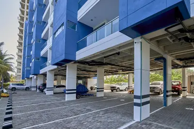 a blue building with cars parked in a parking lot at Magico Apartamento Frente al Mar 2 Habitaciones PAZ124 in Coveñas