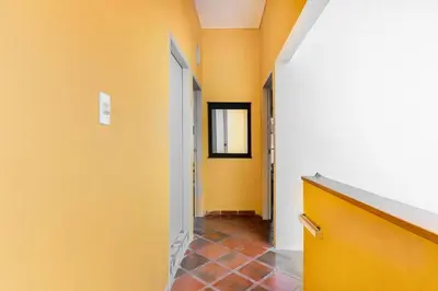 a hallway with yellow walls and a tile floor at JUNTO AL MAR Y EL MANGLAR in Cartagena de Indias