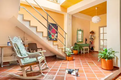 a living room with a staircase and a cat laying on the floor at JUNTO AL MAR Y EL MANGLAR in Cartagena de Indias