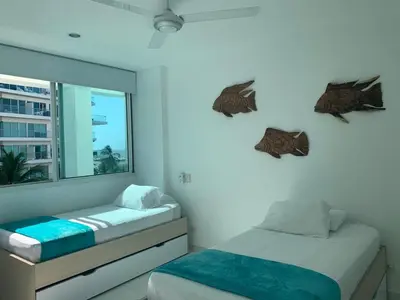 a bedroom with two beds and a mirror at Cartagena Morros 3 Playa in Cartagena de Indias