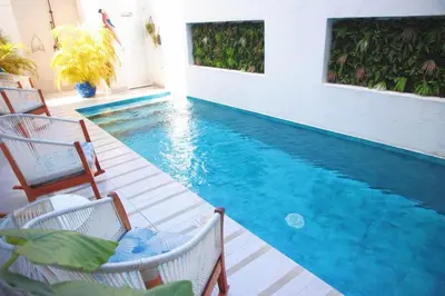 a swimming pool with two chairs and a table at Le MARIE B&B in Cartagena de Indias