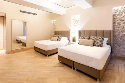 a bedroom with two beds and a mirror at Eurostars Marqués de Villalta in Cartagena de Indias