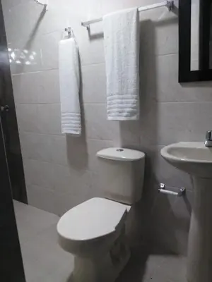 a bathroom with a toilet and a sink with towels at Casa Hotel Manga Mar in Cartagena de Indias