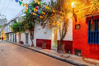 a street with colorful flags on a building at Casa Rachel in Cartagena de Indias