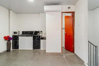 a room with a red door and a kitchen at Casa Rachel in Cartagena de Indias