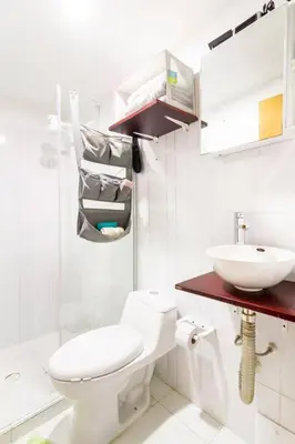 a white bathroom with a toilet and a sink at Casa Rachel in Cartagena de Indias