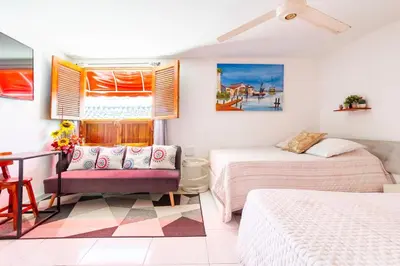a bedroom with two beds and a couch and a table at Casa Rachel in Cartagena de Indias