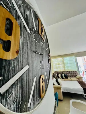 a clock on a wall in a room with a bed at MORROS EPIC luxury in Cartagena de Indias
