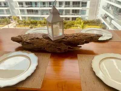 a table with plates and a lantern on top of a log at MORROS EPIC luxury in Cartagena de Indias