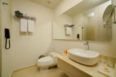 a white bathroom with a sink and a toilet at Hotel Dorado Plaza Alto Prado in Barranquilla
