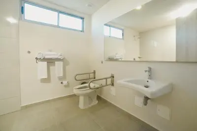 a white bathroom with a toilet and a sink at Hotel Dorado Plaza Alto Prado in Barranquilla