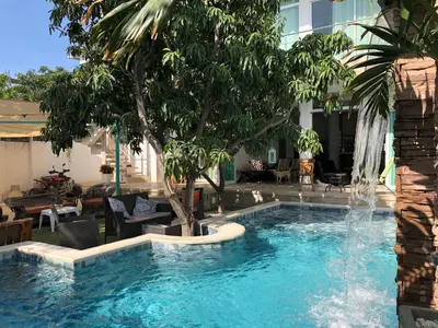 a swimming pool with a tree and water fountain at Ritacuba House Boutique in Santa Marta