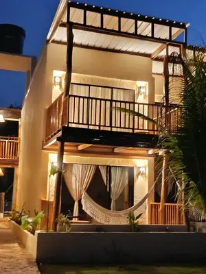 a house with a hammock in front of it at Paraíso Natural Ecohotel in San Bernardo del Viento