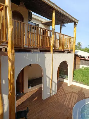 a deck on a house with a patio at Paraíso Natural Ecohotel in San Bernardo del Viento