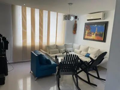 a living room with a couch and a table and chairs at APARTMENT WHITE BOCAGRANDE - Los Delfines in Cartagena de Indias