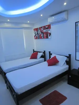 two beds in a room with blue lights at Hotel Valmar in Cartagena de Indias