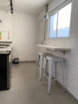 a kitchen with two stools and a counter and a window at Casa San Juan in Cartagena de Indias