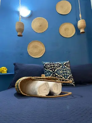 a cat sitting in a bed with a blue wall at Casa San Juan in Cartagena de Indias