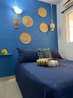 a bedroom with a blue wall with baskets on the wall at Casa San Juan in Cartagena de Indias
