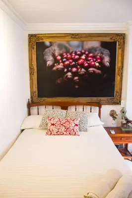 a bedroom with a bed with a painting on the wall at Casa San Benito Abad in Cartagena de Indias