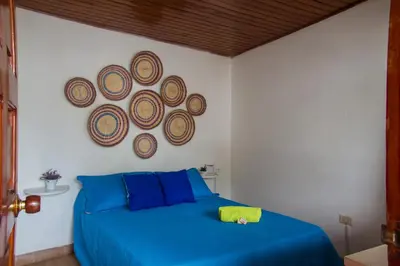 a bedroom with a blue bed and a painting on the wall at Casa San Benito Abad in Cartagena de Indias