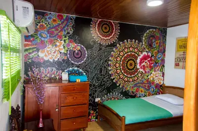 a bedroom with a bed and a dresser and a wall at Casa San Benito Abad in Cartagena de Indias