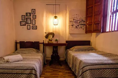 a room with two beds and a table in it at Casa San Benito Abad in Cartagena de Indias