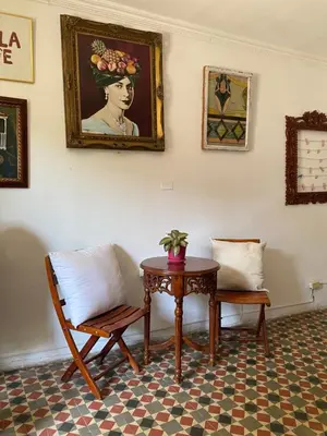 a room with a table and a chair and a painting at Casa San Benito Abad in Cartagena de Indias