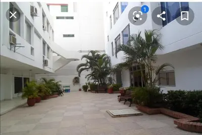 a courtyard of a building with palm trees and benches at Comodo Apartamento en Bocagrande Cartagena 801B in Cartagena de Indias