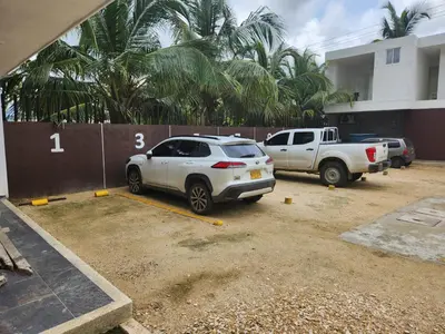 two cars parked in a parking lot in front of a building at Costa Serena Casa 3 in Coveñas