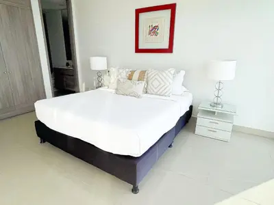 a bedroom with a large bed with white sheets and pillows at 22nd flr Spectacular Seaview Morros City Bocagrande in Cartagena de Indias