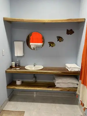 a bathroom with a sink and a mirror at Zéfiro Hostal in San Bernardo del Viento