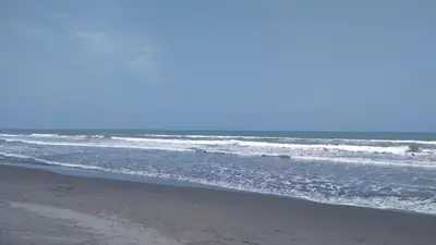 an empty beach with waves in the ocean at Zéfiro Hostal in San Bernardo del Viento