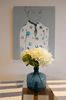a blue vase with white flowers sitting on a table at Classy 1 BR, Pool, Gym near Downtown Cartagena by Huespedia in Cartagena de Indias
