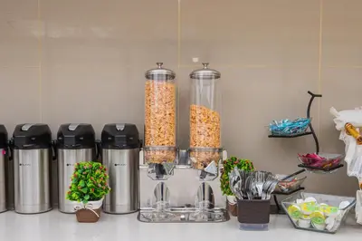 a kitchen counter with two tall containers filled with food at Hotel Avexi Suites By GEH Suites in Cartagena de Indias