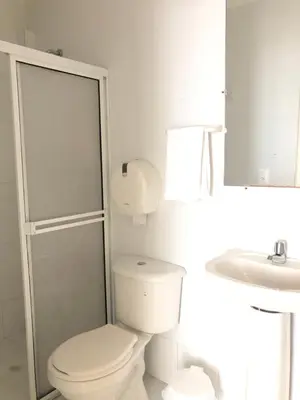 a white bathroom with a toilet and a sink at Hotel Balcones de Bocagrande in Cartagena de Indias