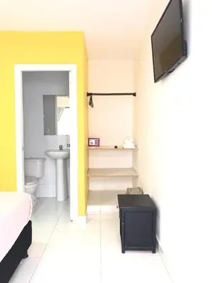 a bathroom with a toilet and a tv on a wall at Hotel Balcones de Bocagrande in Cartagena de Indias