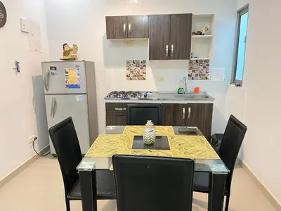 a kitchen with a table and chairs and a refrigerator at Apartamento la Isla 1-Coveñas in Coveñas